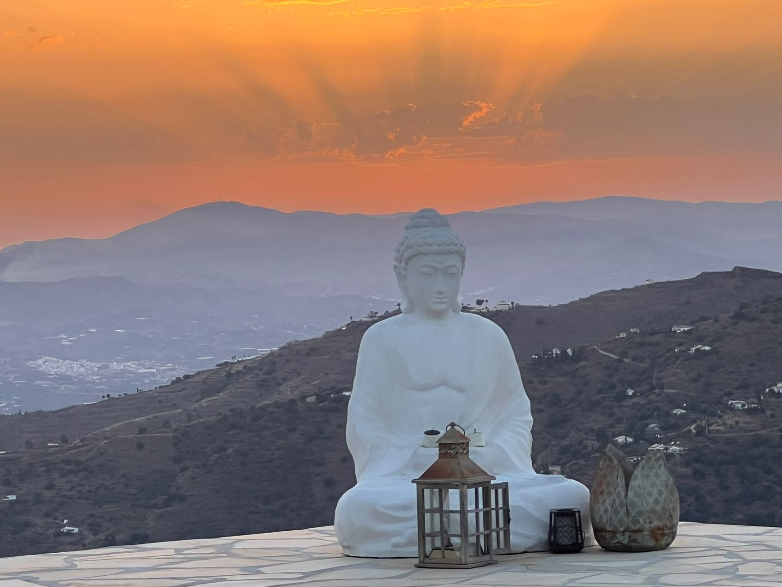 Een witte boeddhabeeld op een bergtop bij zonsondergang in Spanje